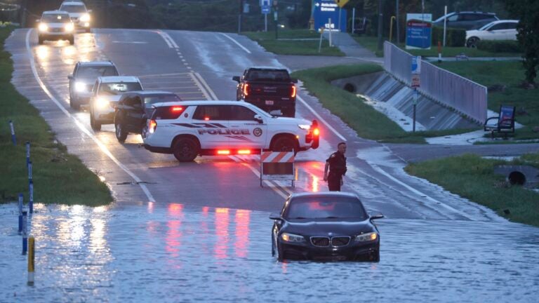 A BMW sedan is stalled in high water along southbound US Alt 19 in Tarpon Springs, Fla., Monday morning.