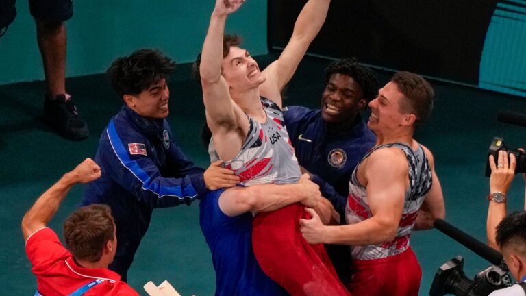 Stephen Nedorscik of the United States is congratulated after the pommel horse during the men's artistic gymnastics team finals at the 2024 Summer Olympics.