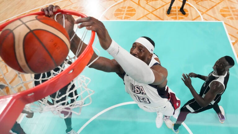Bam Adebayo, of the United States, puts in a basket in front of Peter Jok, of South Sudan, in a men's basketball game at the 2024 Summer Olympics.