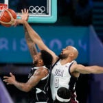 Derrick White, of the United States, blocks the shot of Carlik Jones, of South Sudan, in a men's basketball game at the 2024 Summer Olympics.